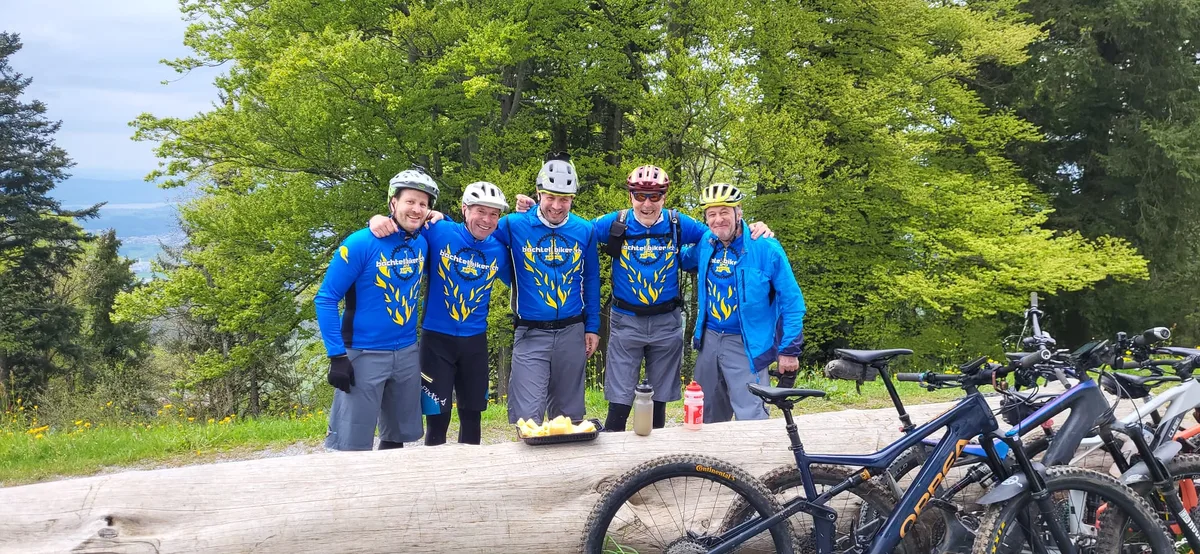 Fünf Männer in Veloshirts posieren für ein Foto.